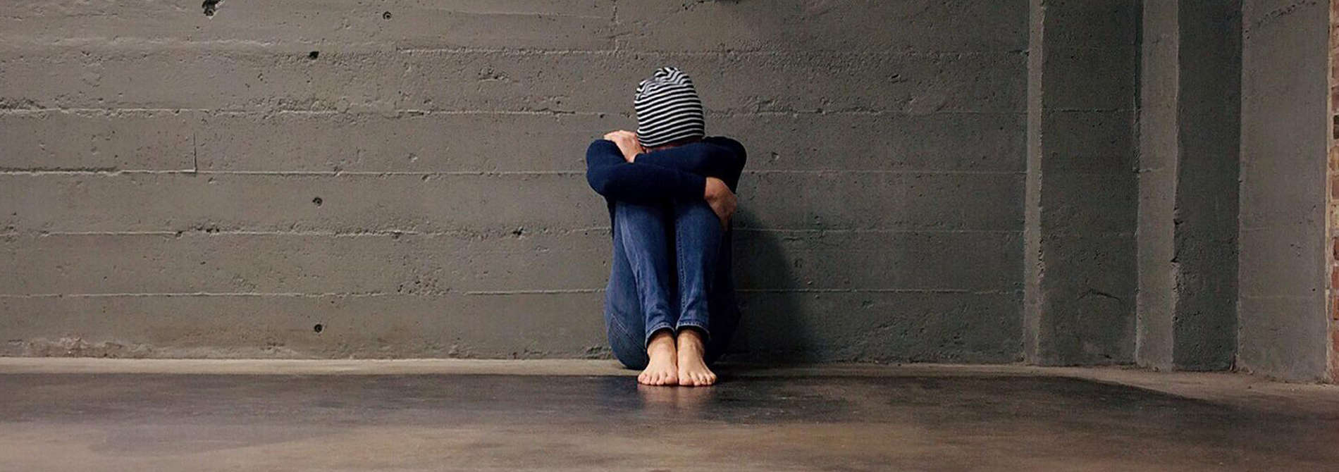 Sad, depressed man sitting on floor