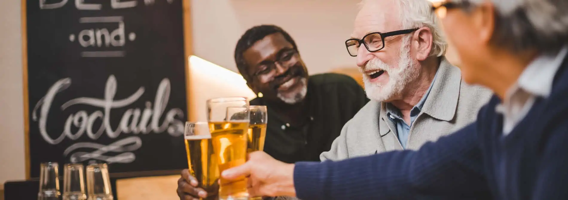 Group of older adult men drinking at a bar