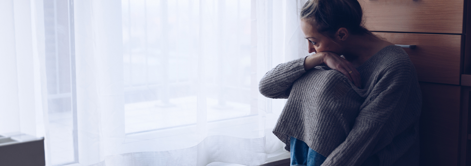 depressed woman looking out window