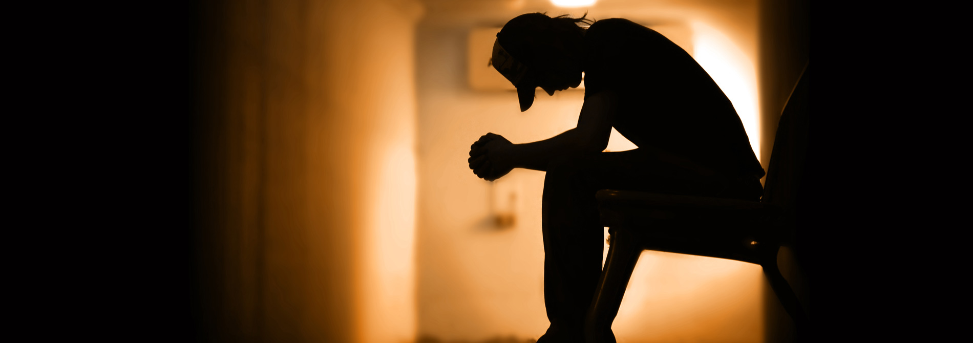 Man sitting on bench in the dark